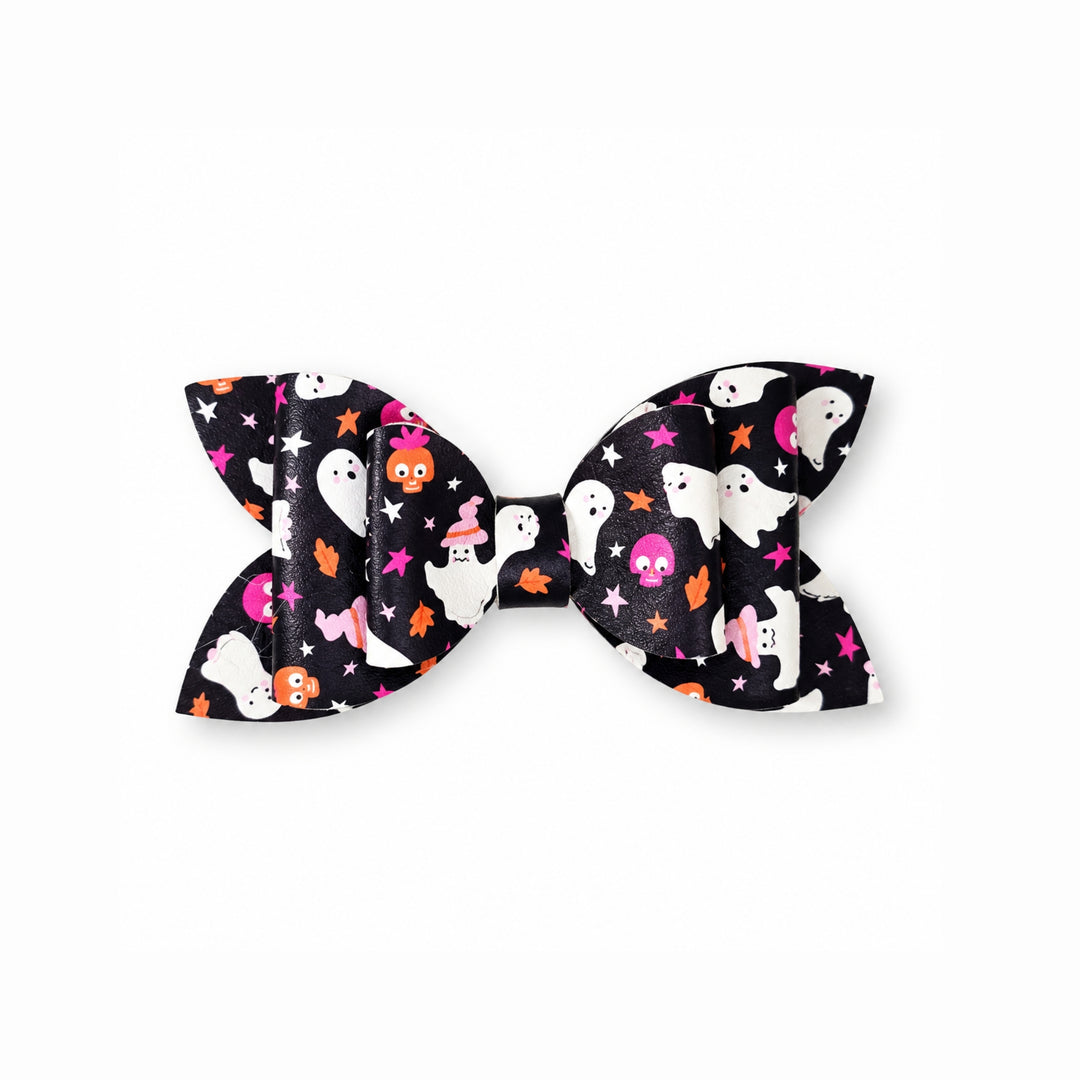 A double-loop bow accessory featuring a black background with a colorful Halloween print of white ghosts, orange pumpkins, pink stars, and white stars.