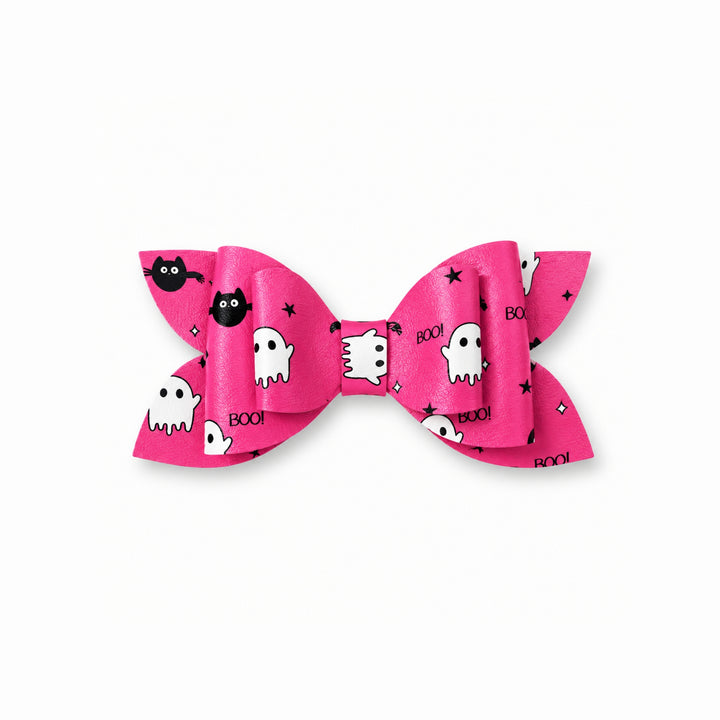 A pink hair bow with a Halloween pattern featuring white ghosts, black bats, black stars, and the word &